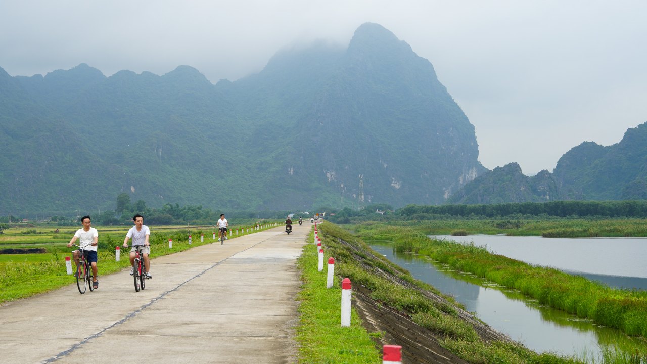 Cyclists exploring the quiet dyke roads and wetlands of Van Long